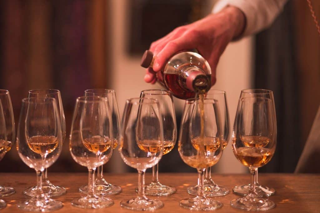 Pouring fine whisky into glasses, setting the scene for a suit jacket selection guide