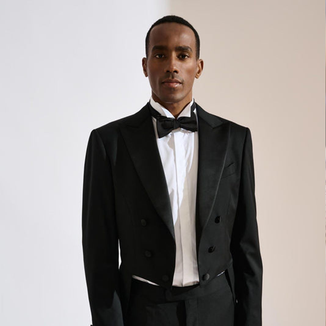 Classic black tuxedo with a satin shawl lapel and bow tie, styled for a black-tie event.