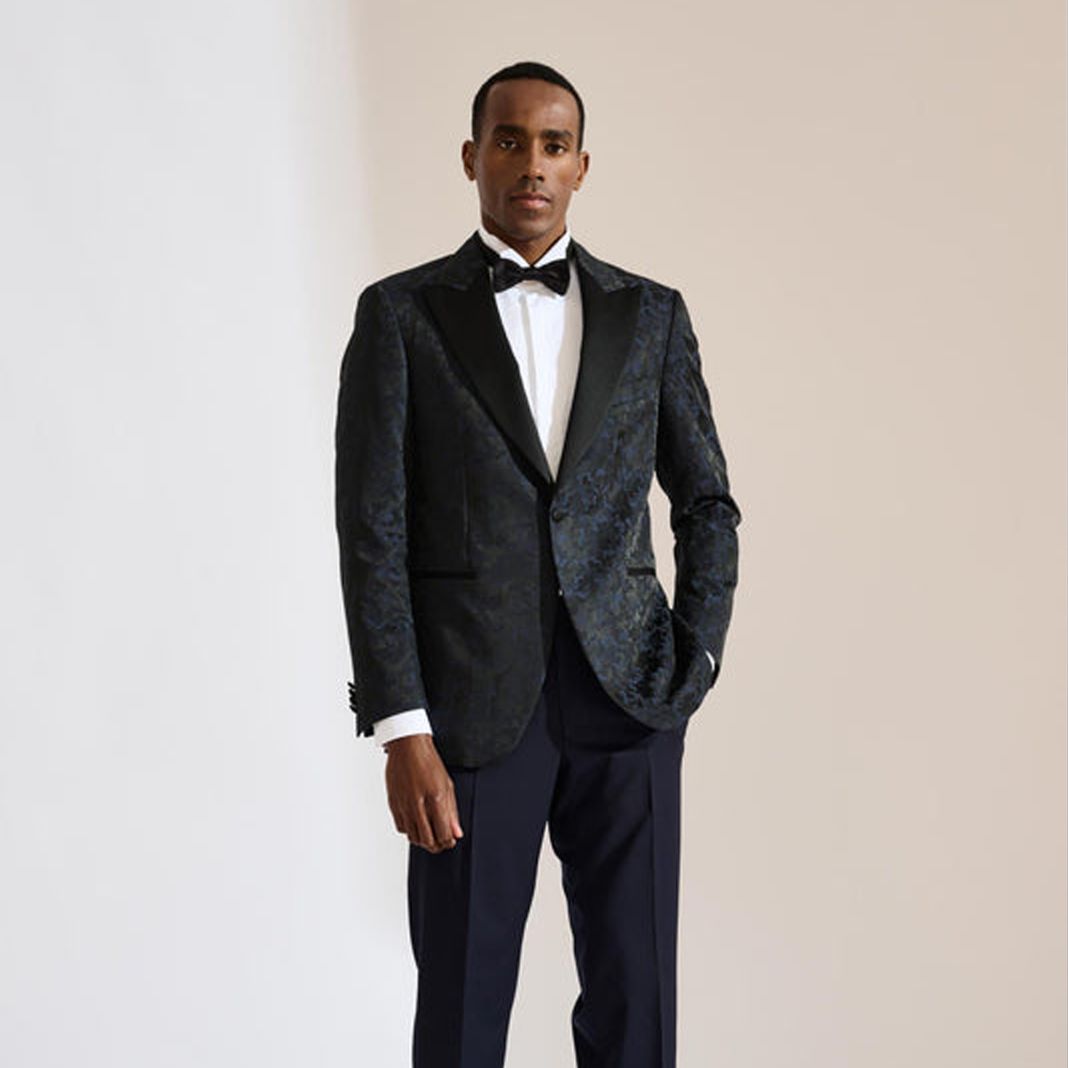 Full-length view of a classic black dinner suit styled with patent leather shoes