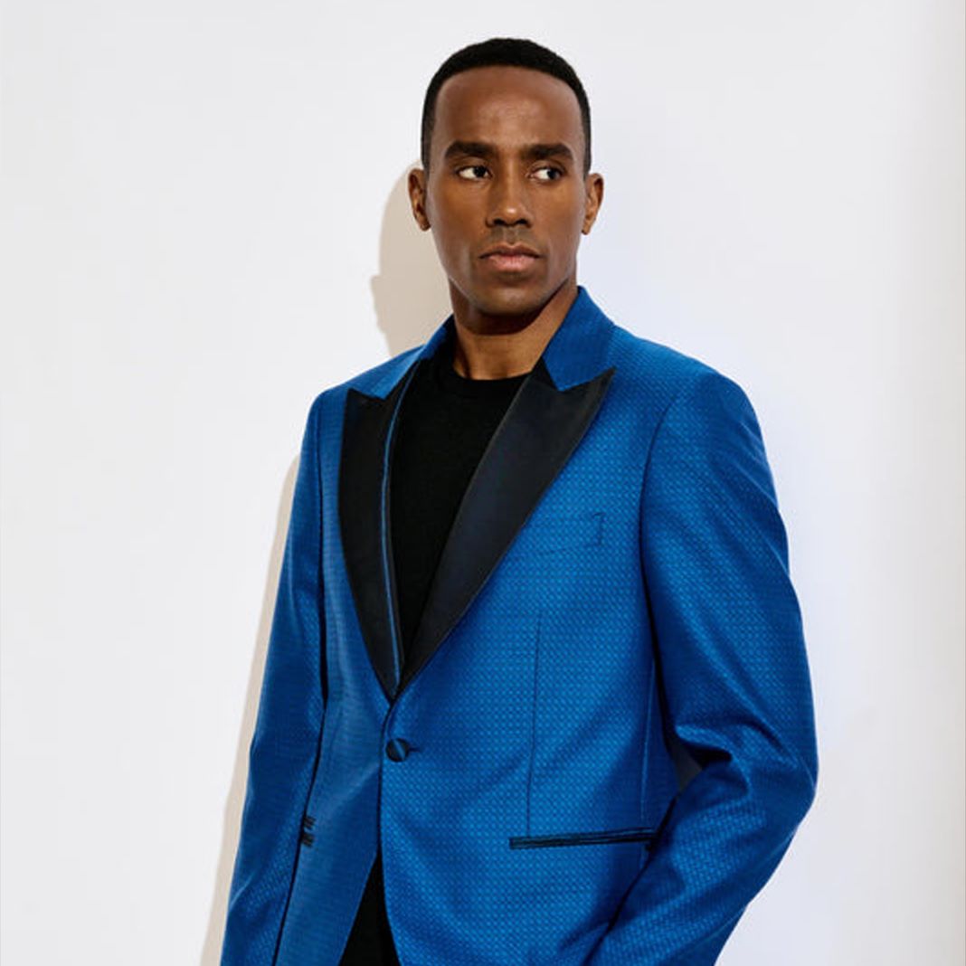 Tailored rich blue dinner jacket with custom gold detailing, perfect for a high-profile evening event.