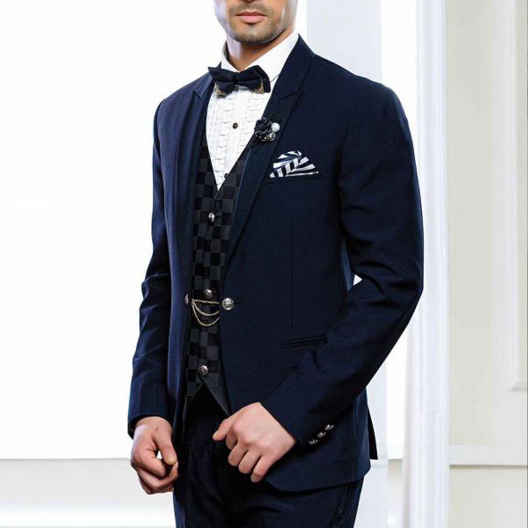 Man wearing a navy dinner suit with peak lapels, paired with a crisp white shirt and black bow tie.