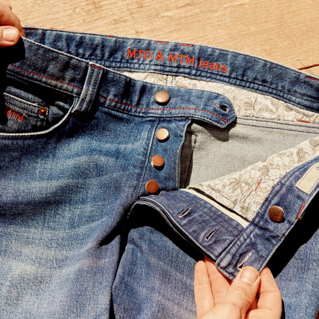 Distressed blue jeans with subtle rips and a tapered fit for a trendy look