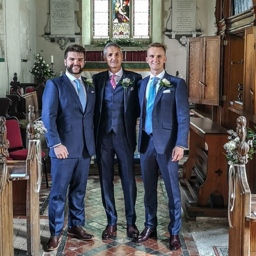 Classic navy lounge suit with a single-breasted jacket, white shirt, and coloured tie for a wedding.