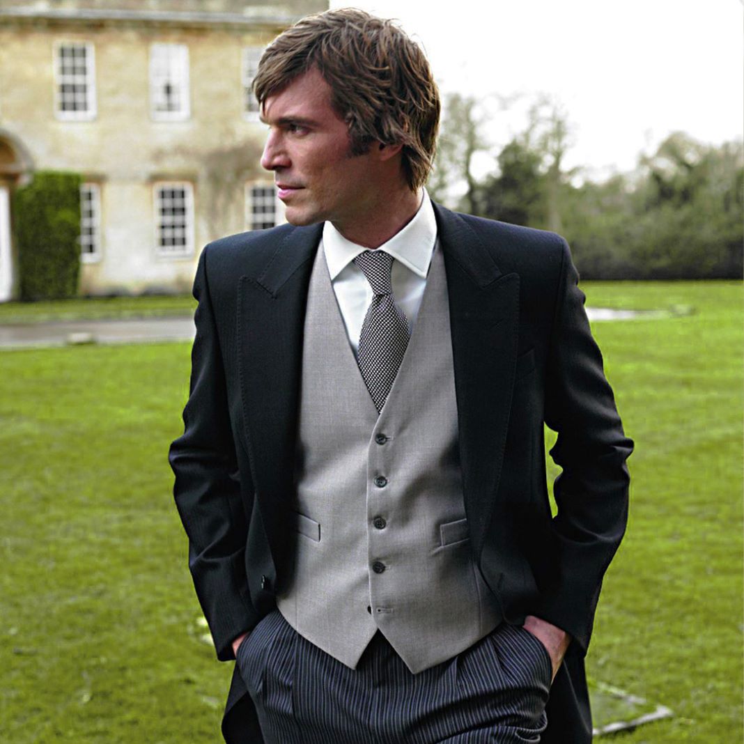 Classic morning suit with a black tailcoat, grey striped trousers, and a grey waistcoat for a traditional wedding