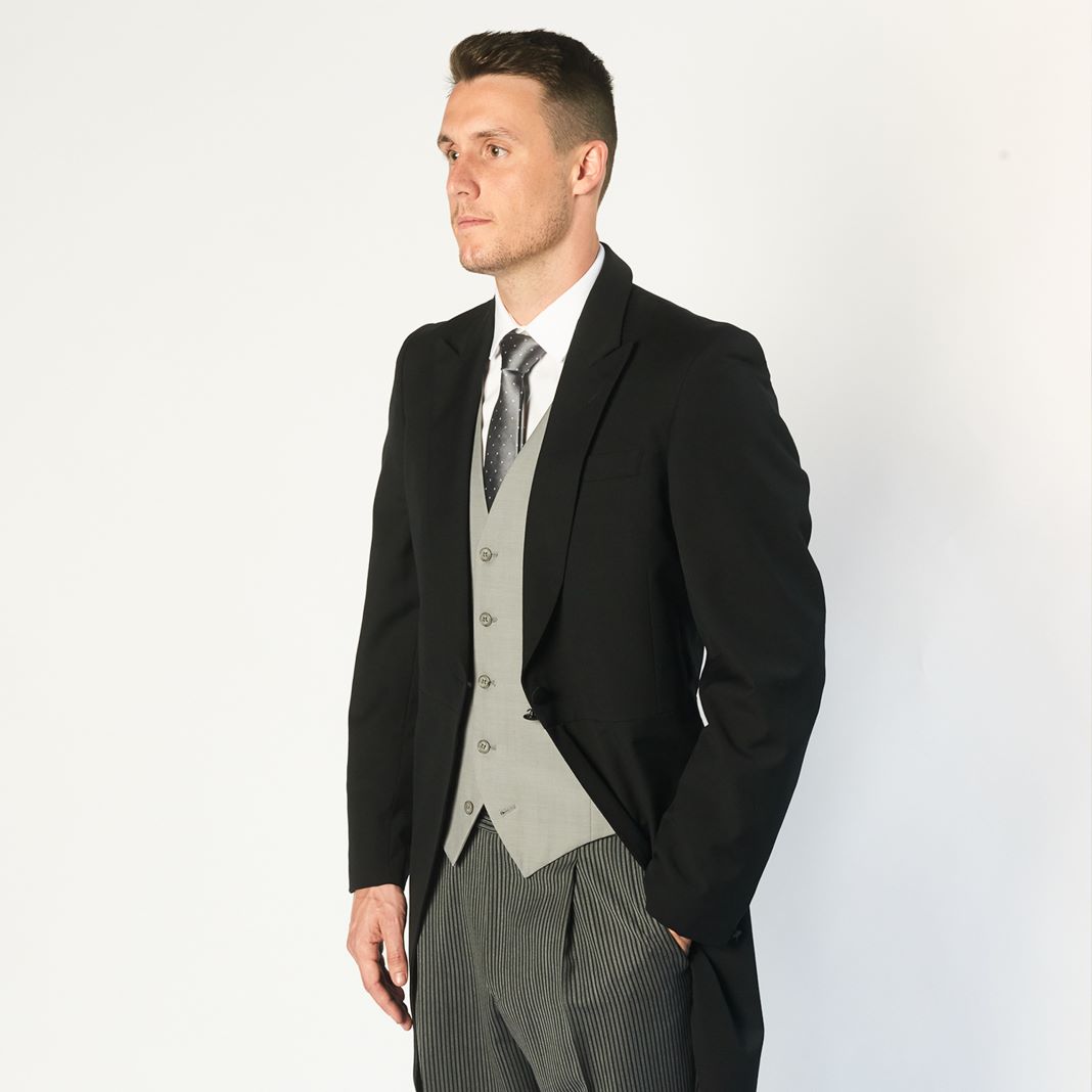 Traditional black morning suit paired with a double-breasted waistcoat and patterned tie.