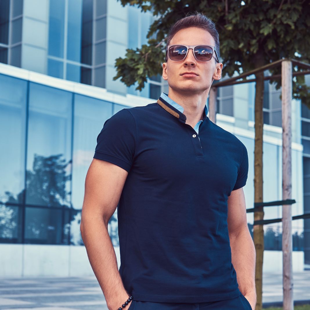 Close-up of a tailored navy polo T-shirt with a smart collar and button detail