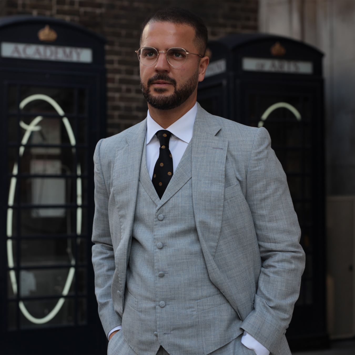  a photo of a man in a grey three piece suit looking dashing