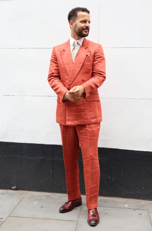 Bold coral suit with white shirt and brown loafers – a vibrant statement for race day.