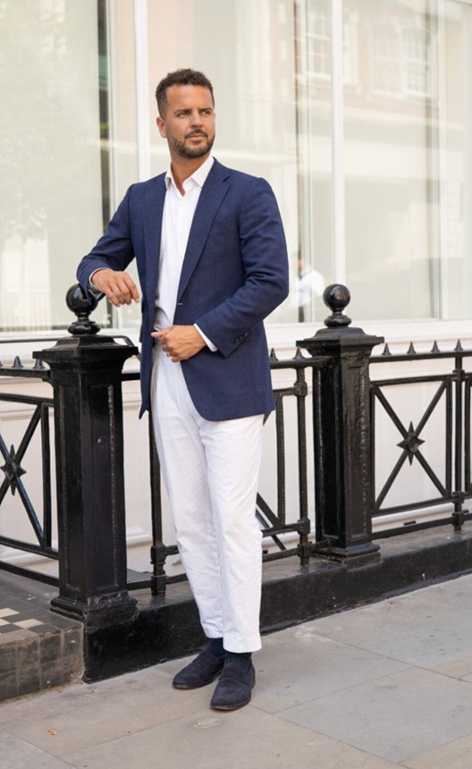 Man wearing a navy blazer with white trousers and loafers, ideal for summer race day.