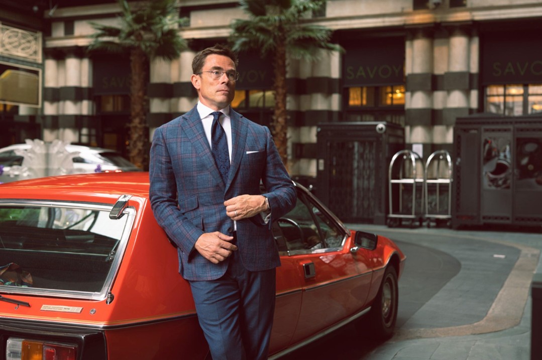 A photo of a bespokely dressed man outside of The Savoy In London