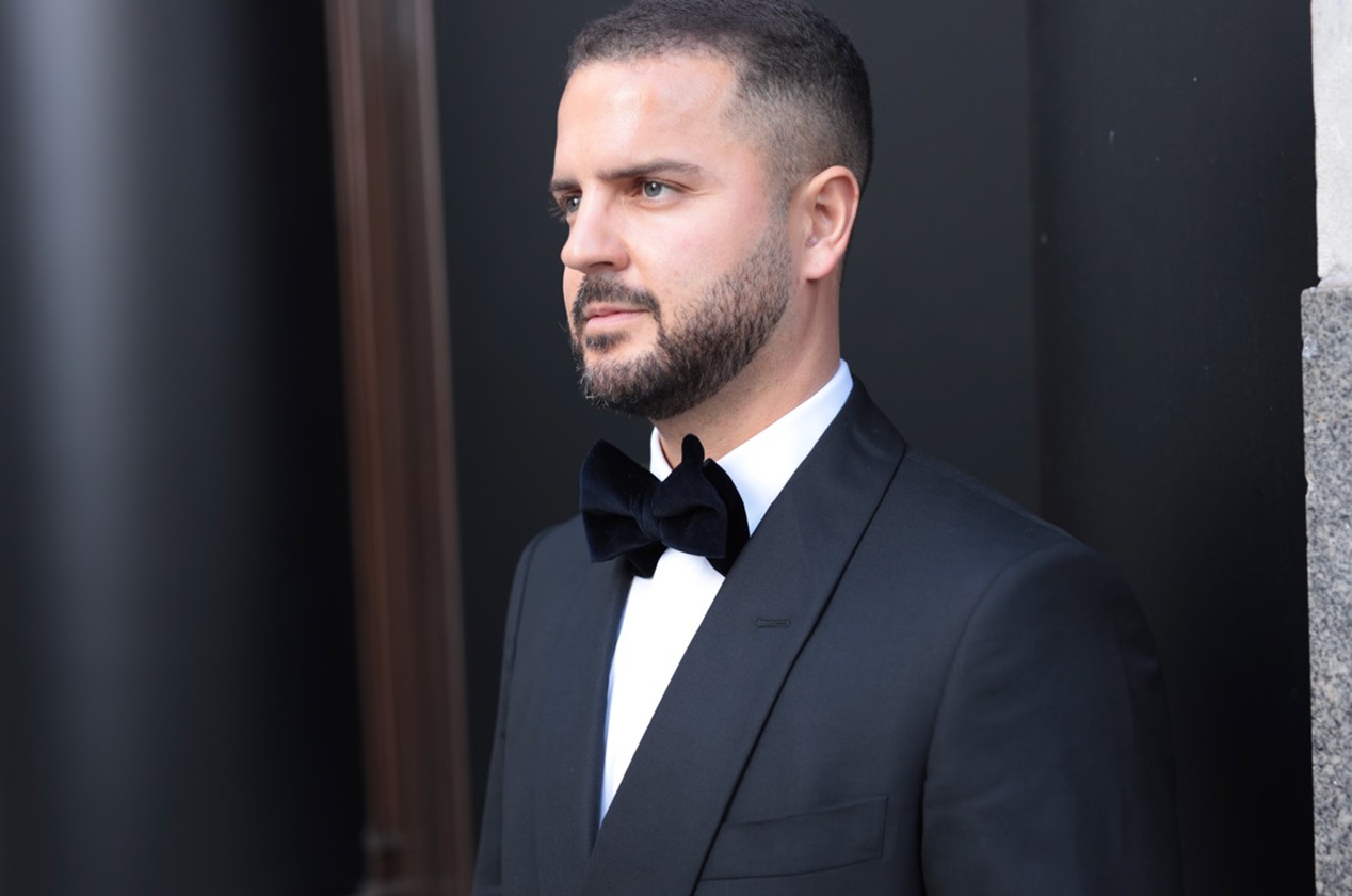 A photo of a gentleman dressed in a black suit and black bow tie ready for a night out