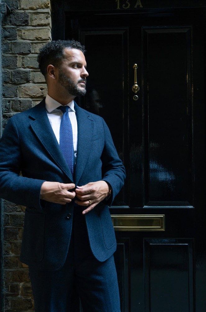 A photo of a man in a tweed suit at night