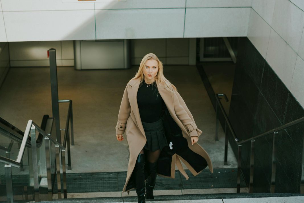 a photo of a woman wearing a wool coat walking up stairs - pexels