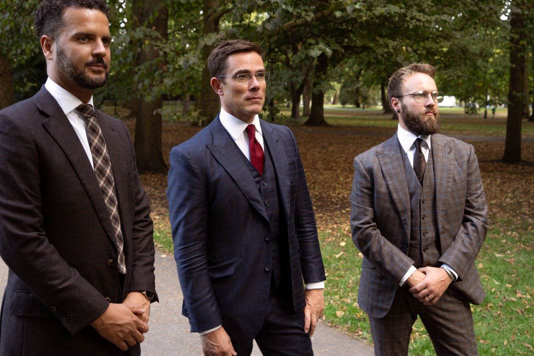 three men wearing bespoke suits in green park, london