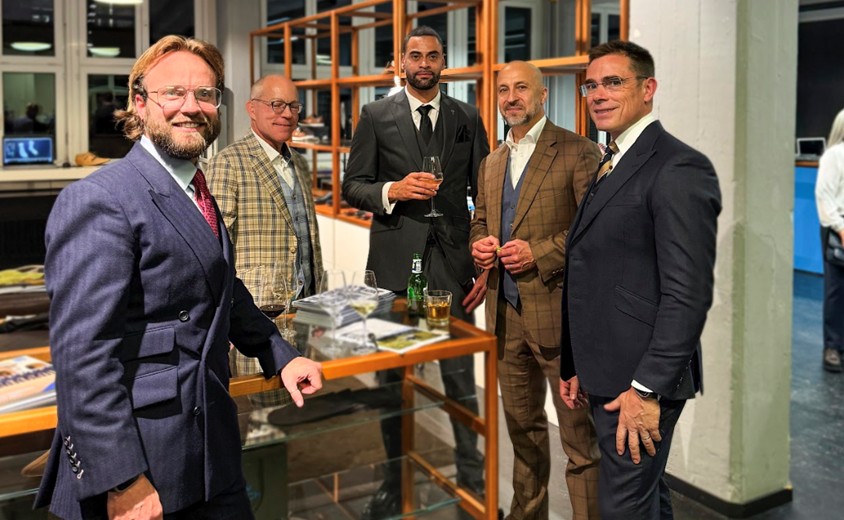 Group of men in premium tailored suits inside a Zurich tailoring showroom, reflecting professional and classic menswear.