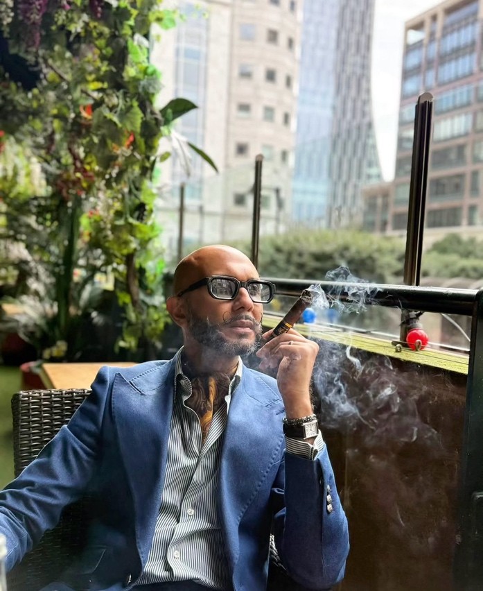A man in a tailored suit relaxing in a chic urban lounge, reflecting sophisticated metropolitan menswear.