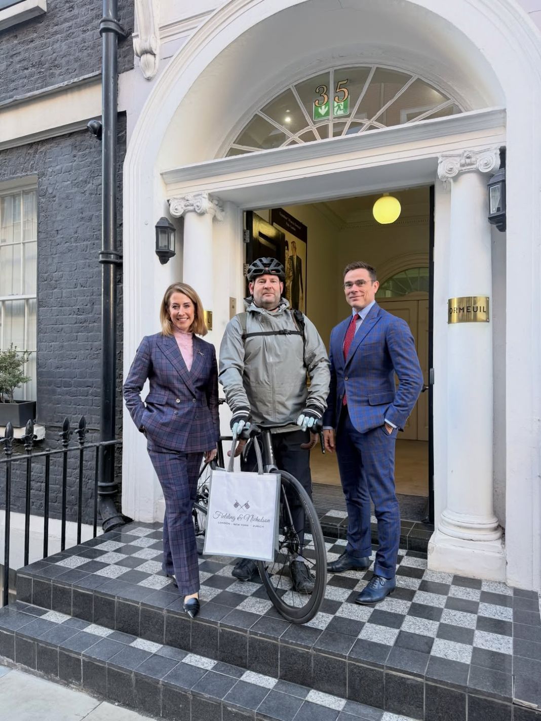 Two london tailors with a bespoke client