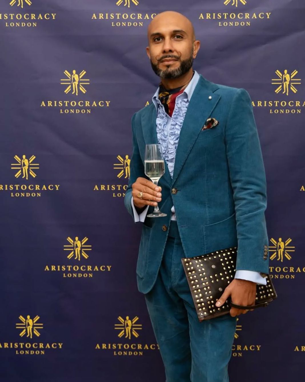 a photo of a tailor at an event in london wearing a bespoke suit