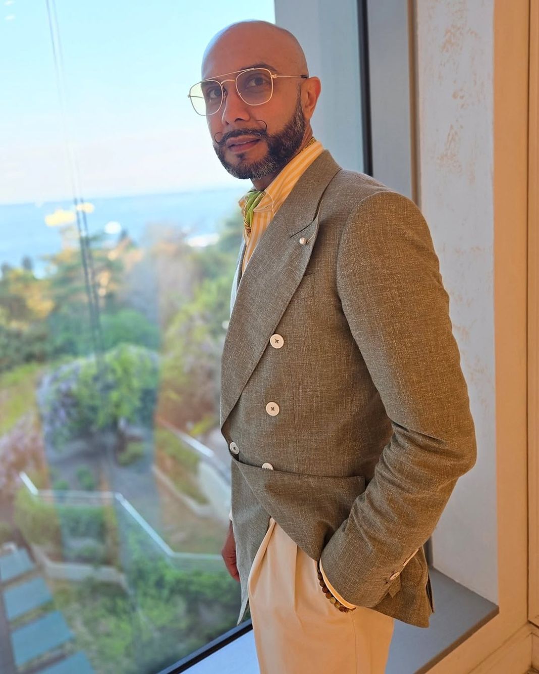 a photo of dapper rav looking fresh on holiday in a bespoke outfit