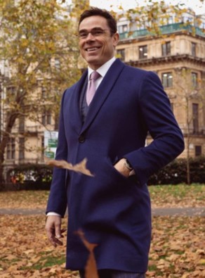 A photo of ian the founder of fielding and nicholson wearing a royal blue overcoat