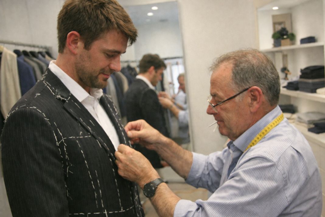 An illustrative photo of a baste fitting in a tailors taking place