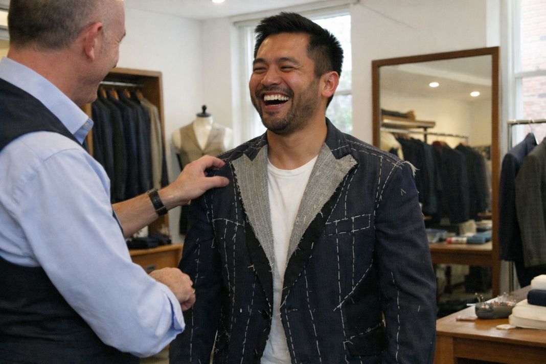 An illustrative photo of a casual fitting session in a London tailoring showroom