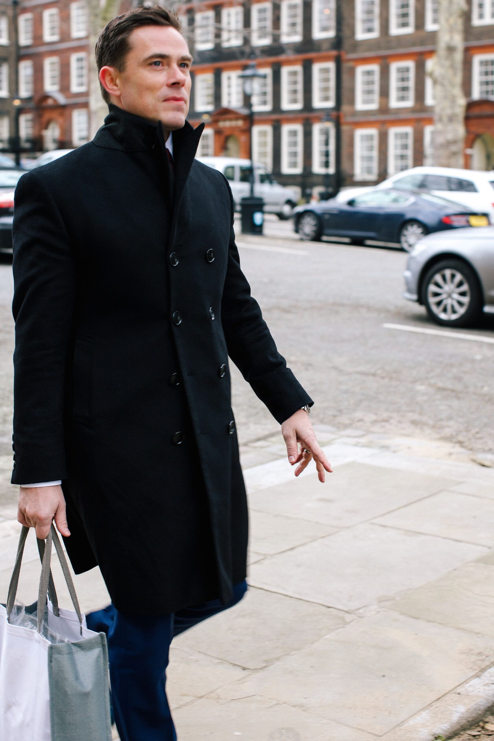 Black tailored overcoat worn with a turtleneck, sample image