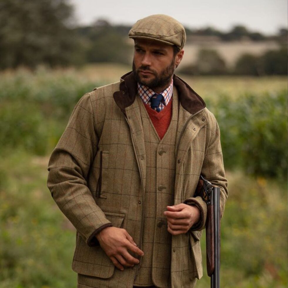 Brown country shooting jacket worn with a flat cap, sample image
