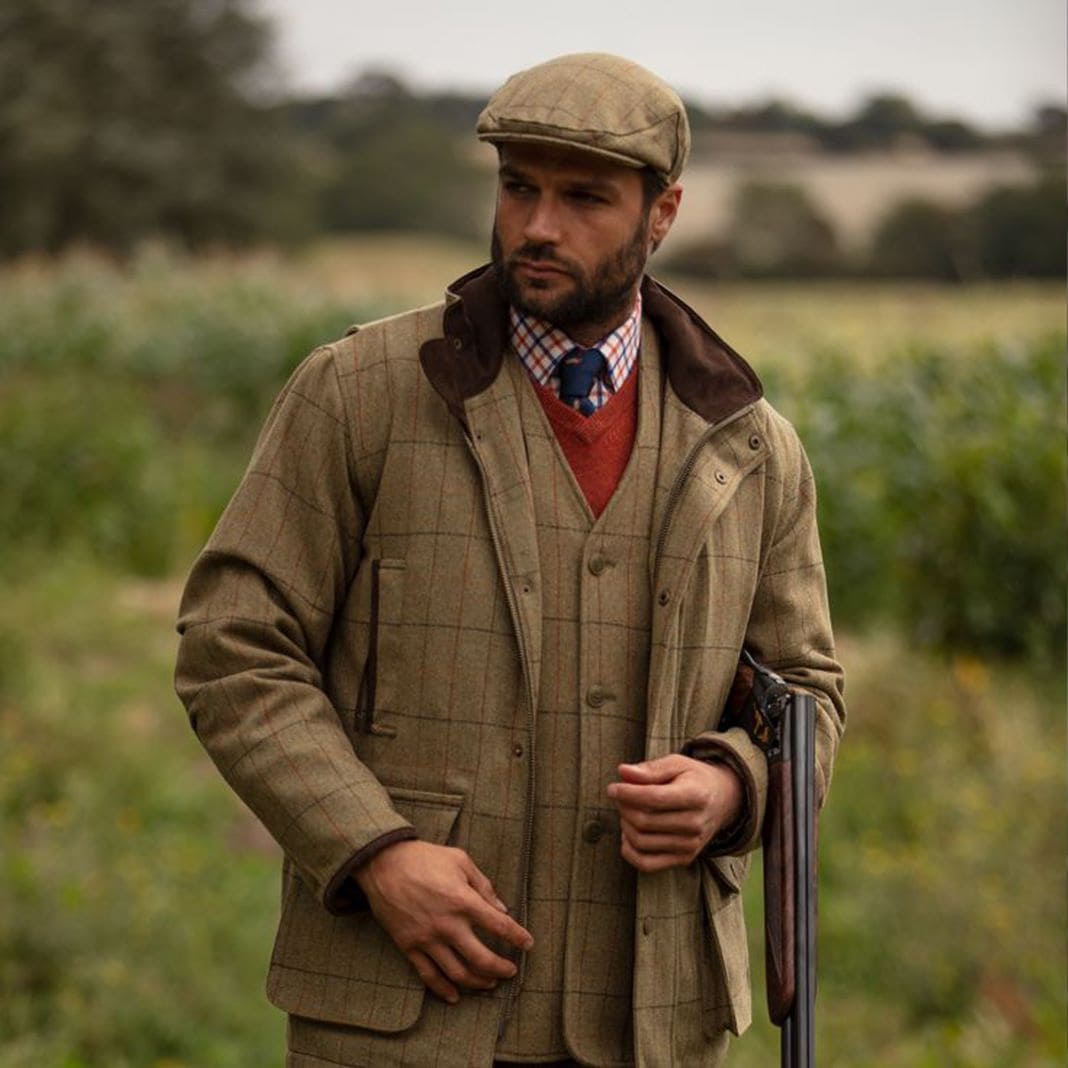 Brown country shooting jacket worn with a flat cap, sample image
