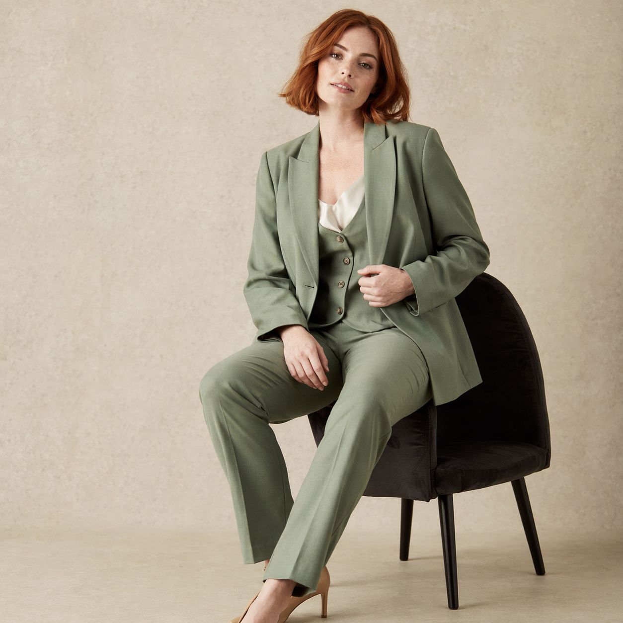 Sage green tailored blazer worn with straight-leg trousers