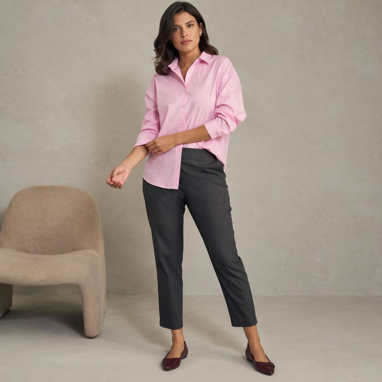 Pink button-up shirt worn with dark slim-fit trousers