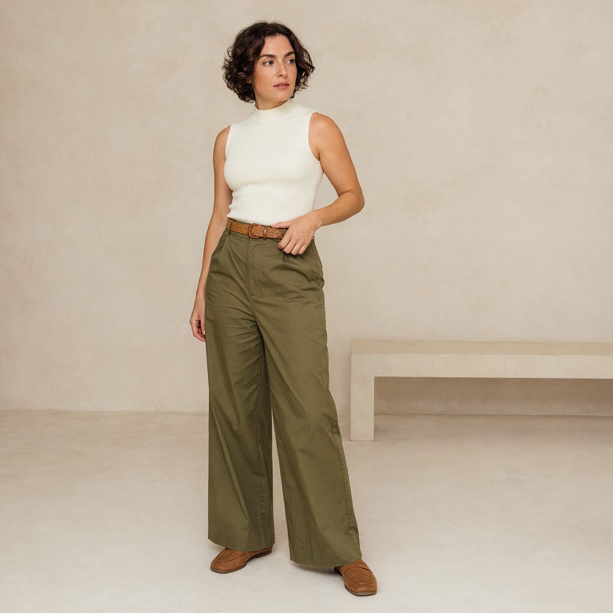 White sleeveless top worn with olive wide-leg trousers, sample image