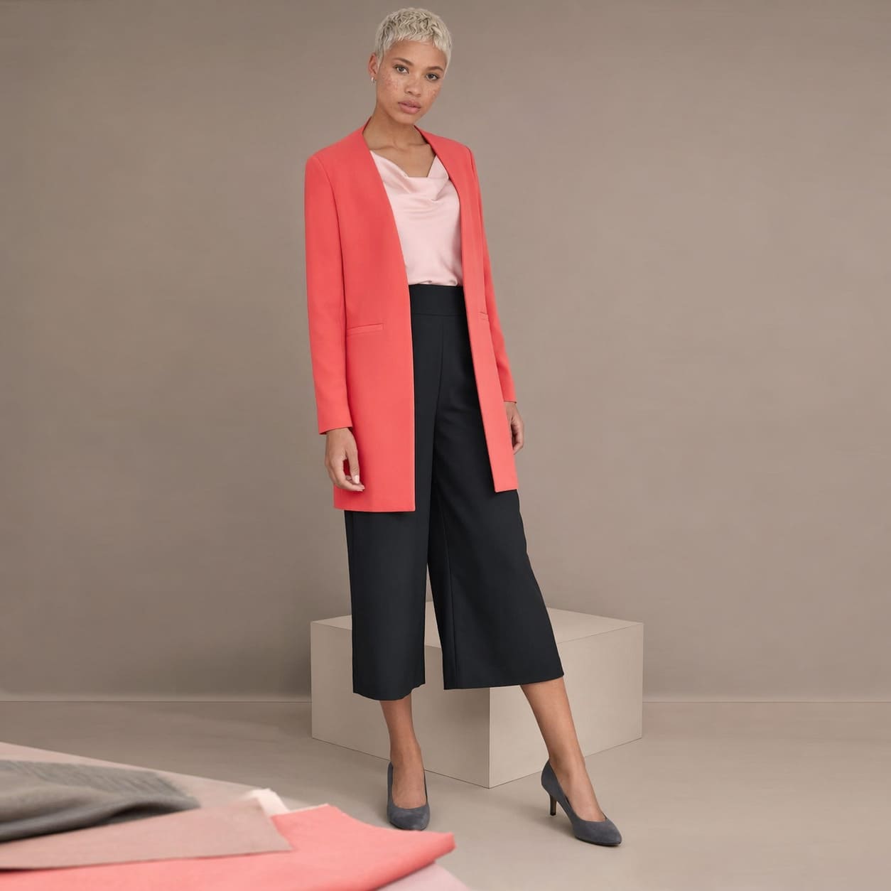 Coral longline blazer worn with dark cropped trousers