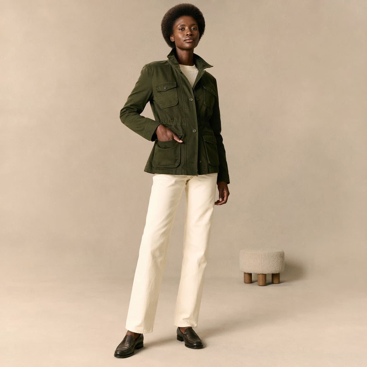 Dark green tailored jacket worn with cream straight-leg trousers, sample image