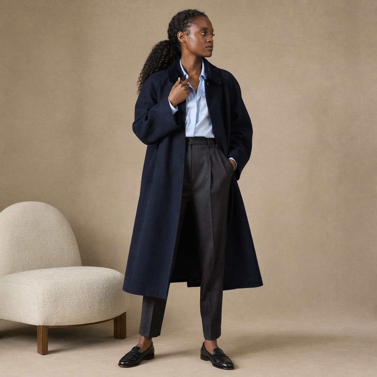 Navy longline coat worn with tailored black trousers, sample image