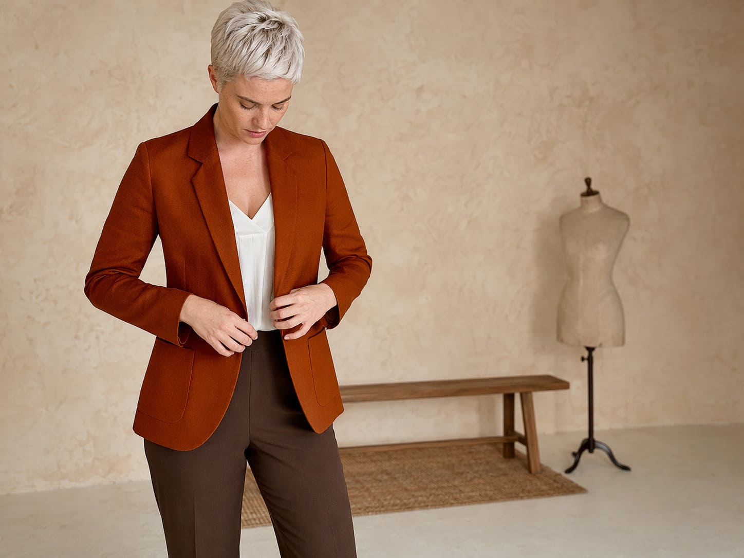Rust blazer worn with brown trousers and a neutral top, sample image