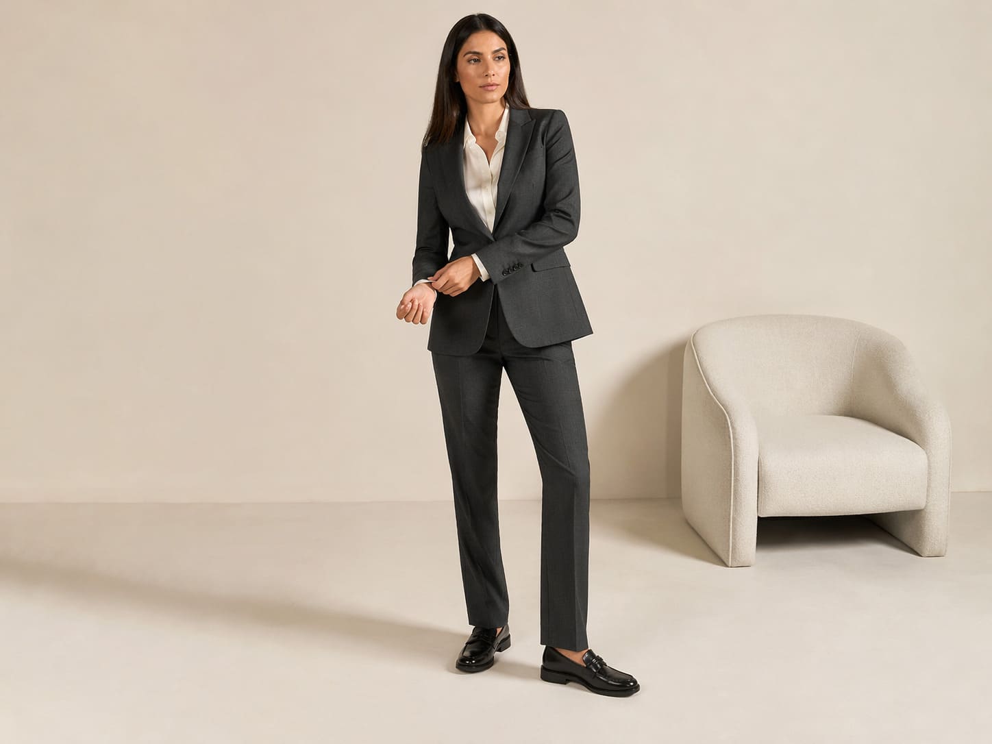 Woman in a charcoal tailored blazer with slim fit trousers, sample image