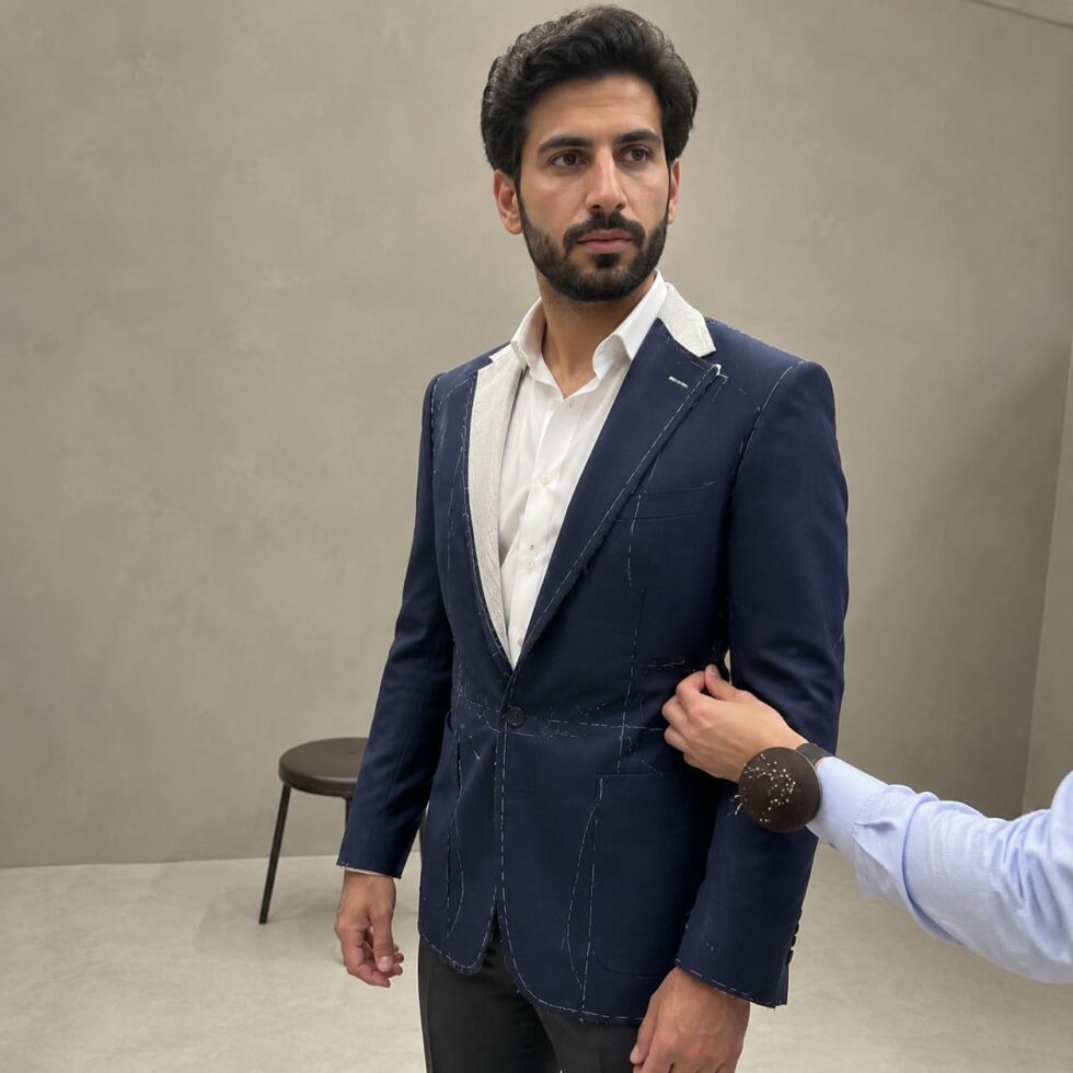 Partly finished navy suit jacket during a fitting, sample image