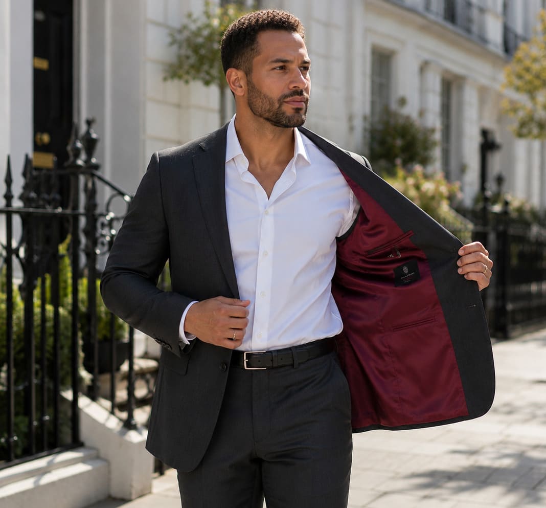 A man showing the inside lining of his bespoke suit