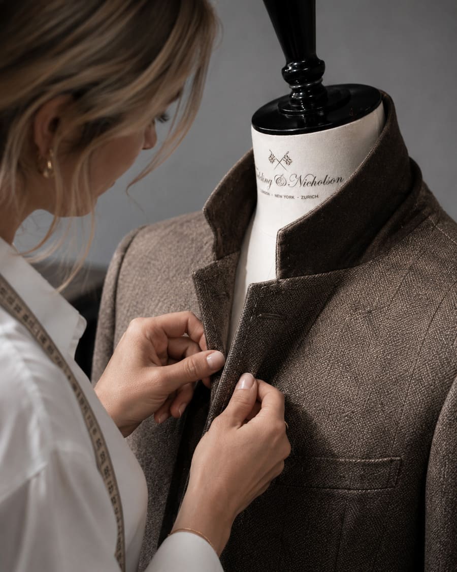A tailor stitching a tailored jacket