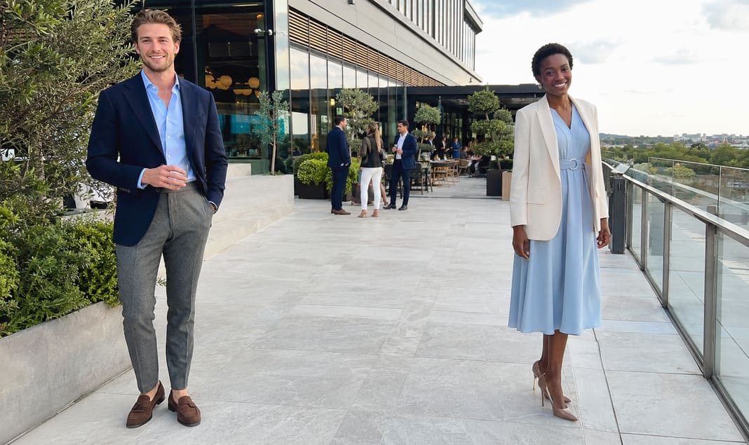 Men's navy blazer with grey trousers demonstrates successful blazer separates, while the woman's white blazer over a light blue dress shows how tailored jackets can complement outfits without matching trousers or a full suit.