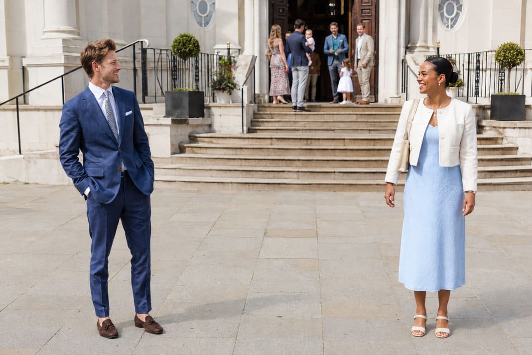 A navy tailored suit with brown shoes is paired with a light blue midi dress and ivory blazer, illustrating timeless summer christening outfits that combine smart tailoring with elegant occasionwear for warm-weather events. A navy tailored suit with brown shoes is paired with a light blue midi dress and ivory blazer, illustrating timeless summer christening outfits that combine smart tailoring with elegant occasionwear for warm-weather events.