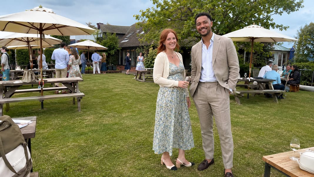 A beige tailored suit with an open-collar shirt is paired with a pale green floral midi dress, showcasing stylish summer christening outfits that combine lightweight tailoring with elegant seasonal occasionwear. A beige tailored suit with an open-collar shirt is paired with a pale green floral midi dress, showcasing stylish summer christening outfits that combine lightweight tailoring with elegant seasonal occasionwear.