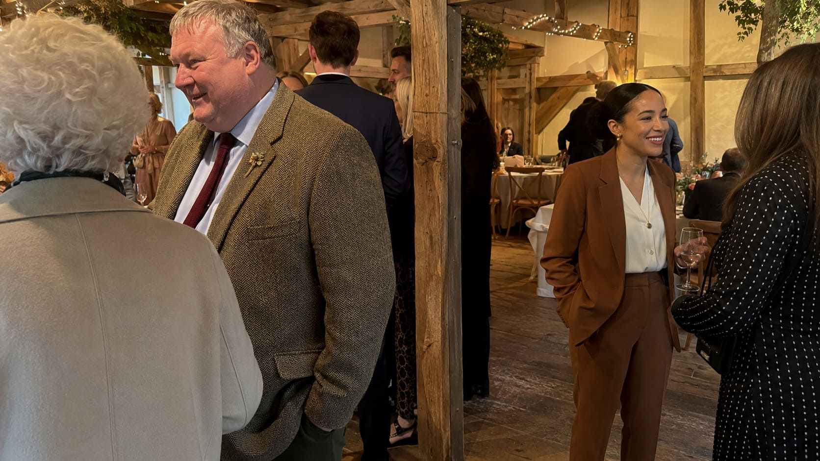 Men wearing brown and camel tailoring compare autumn fabrics inside a bespoke clothing studio.