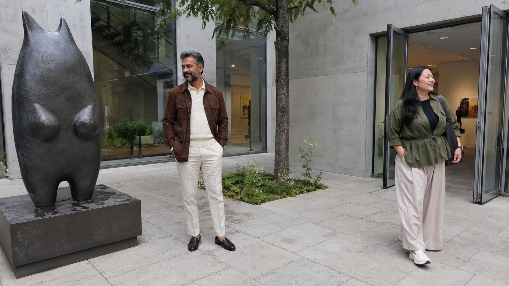 Women wearing cream and dark green tailored outfits attend London Fashion Week city events. Women wearing cream and dark green tailored outfits attend London Fashion Week city events.