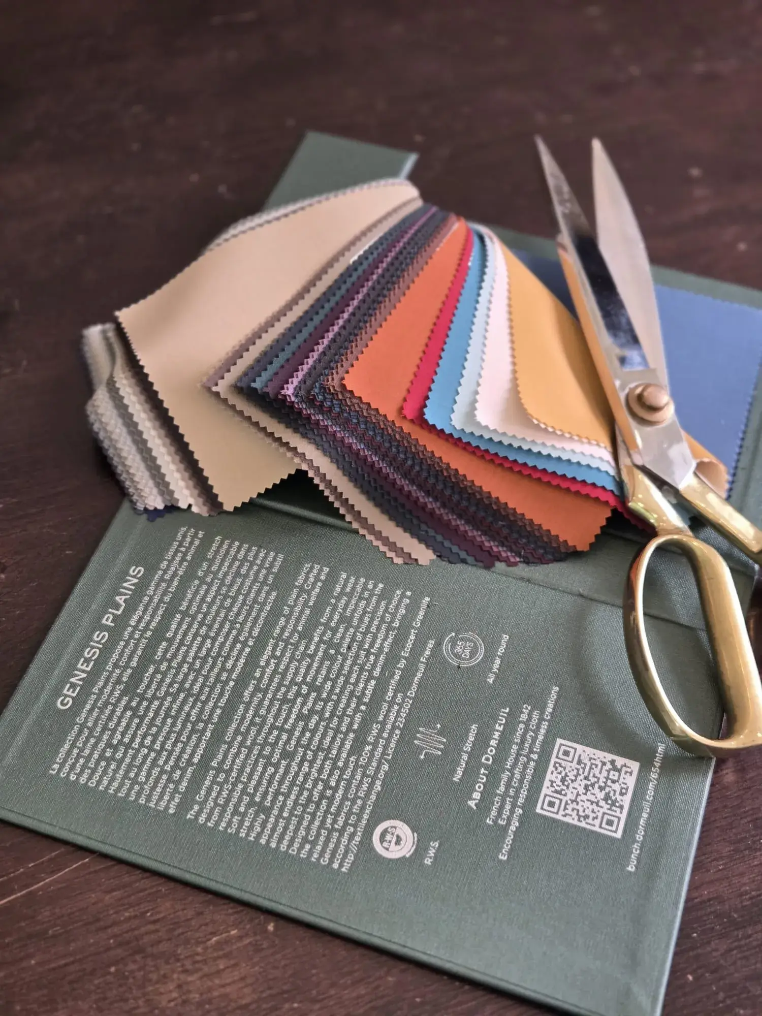 Colourful cloth swatches fanned out with gold shears and swatch book Colourful cloth swatches fanned out with gold shears and swatch book