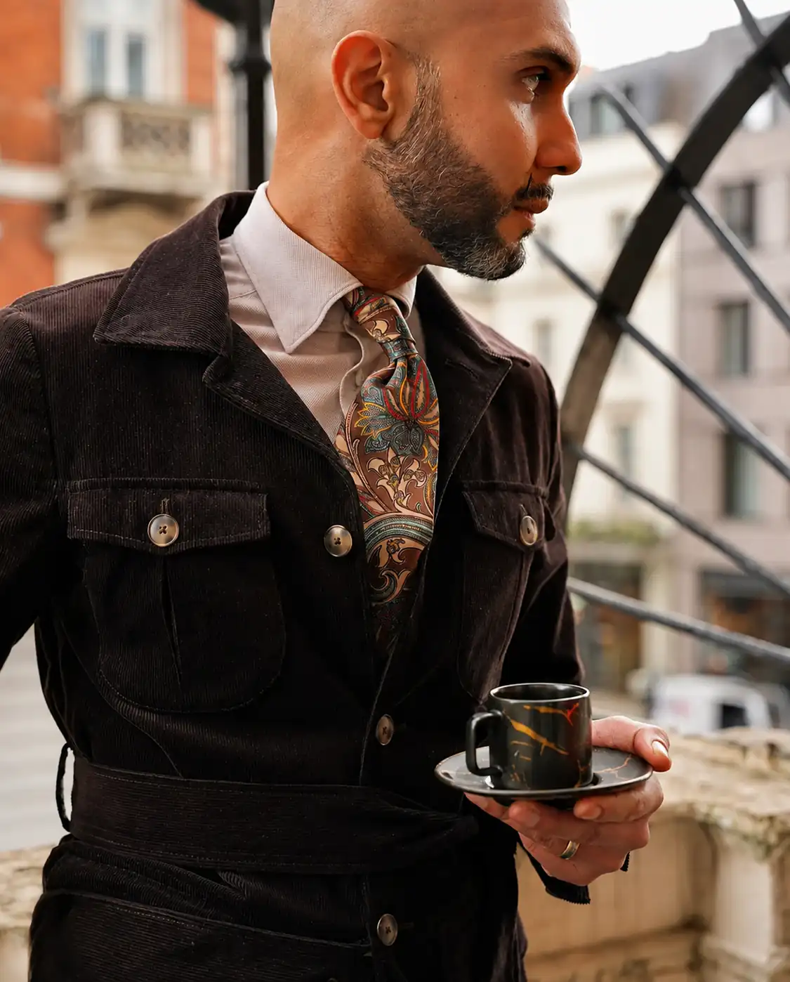 Dark brown corduroy belted jacket worn with a paisley tie