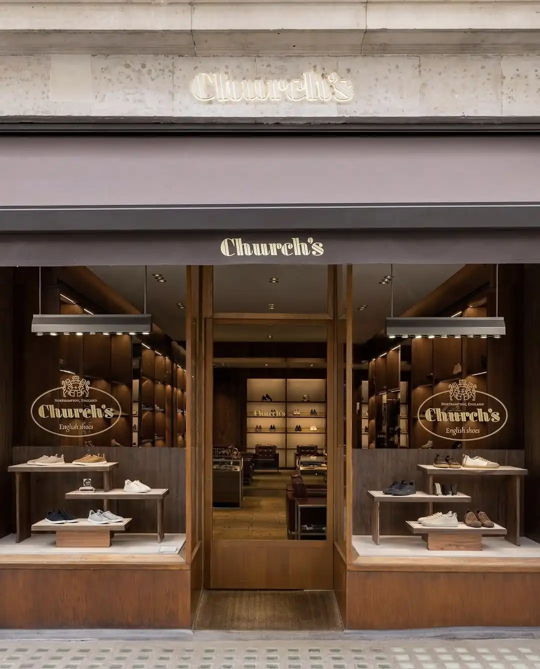 Church's shoe boutique storefront with lit window displays