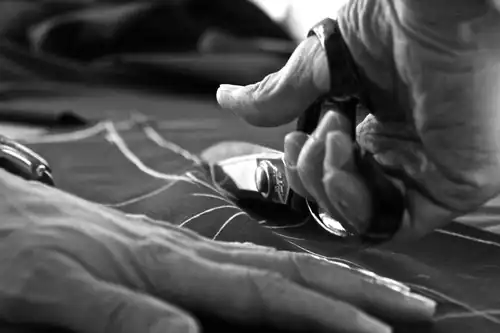 Tailor cutting suit cloth by hand with traditional shears